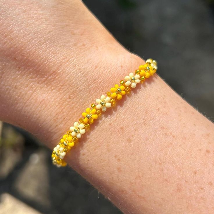 The perfect summer accessory - this cute yellow and gold flower beaded bracelet. You can even size up to style as an anklet! the perfect gift or treat for yourself. Explore more beaded bracelets and accessories at Dainty and Shine ✨  Size and details: Measuring 16cm with a 4.5cm extender chain, it offers a perfect fit for any wrist.  11/0 seed beads, and gold plated stainless steel clasp. Care instructions:  To keep it looking its best, gently wipe the bracelet with a soft cloth after wear to remove any oils or dirt. Avoid exposing it to water, perfumes, or lotions to maintain its delicate beauty over time.