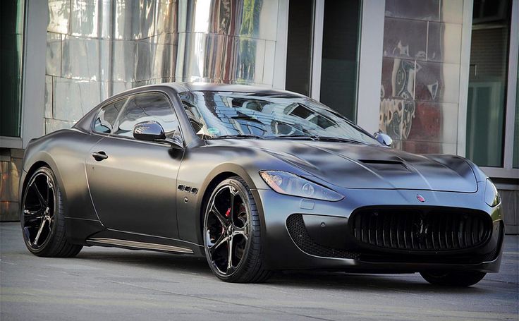 a silver sports car parked in front of a building