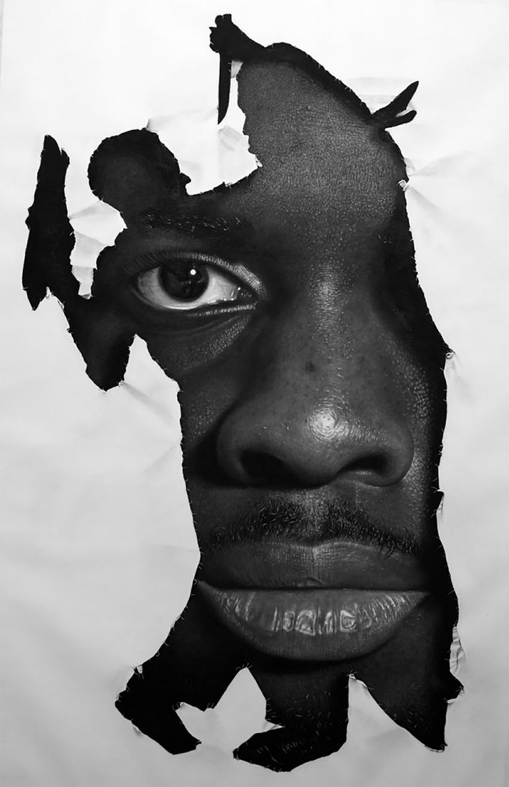 a black and white photo of a man's face with torn paper on it