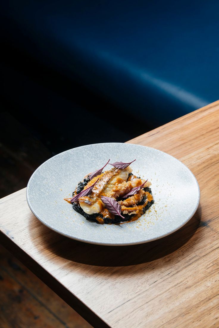 a white plate topped with food on top of a wooden table