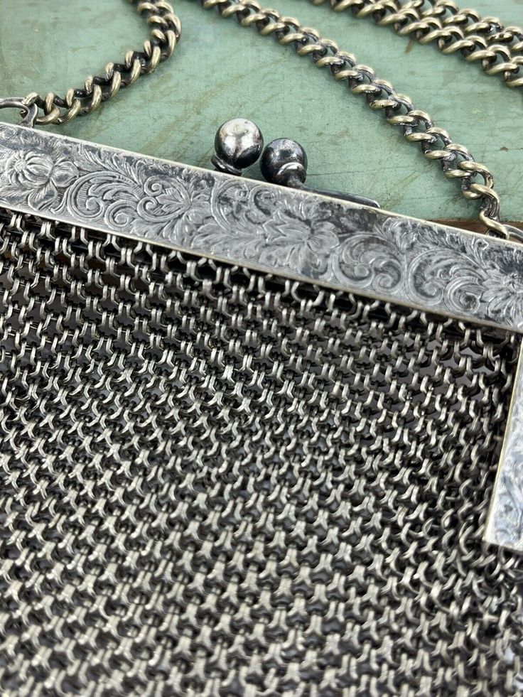 a close up of a chain mail bag with a metal clasp on the front and side