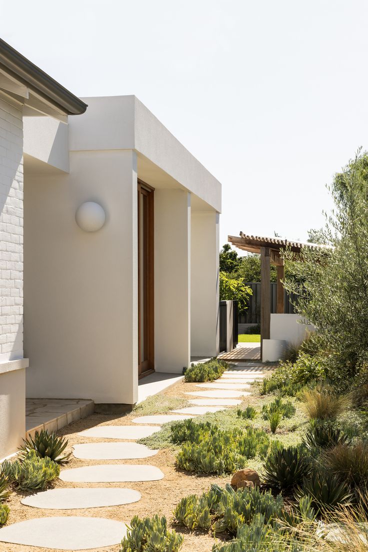 a white house with stone pathway leading to the front door