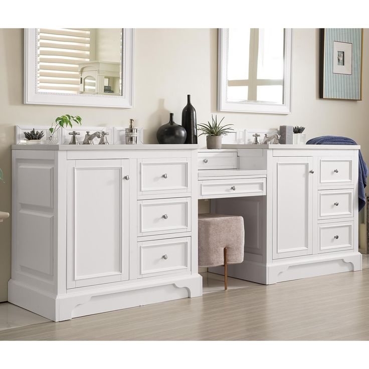 a white bathroom with two sinks and mirrors