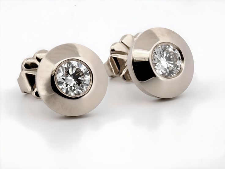 These stunning earrings are crafted from luxurious 14K white gold, exuding a timeless elegance that is both modern and classic. Each earring is set with a brilliant round-cut natural diamond, totaling 0.40 carats across the pair. The diamonds are securely nestled within the gold, creating a captivating contrast between the warm golden hue and the sparkling clarity of the gemstones. These earrings are perfect for adding a touch of sophistication to any outfit, whether for everyday wear or special occasions. The design is both refined and versatile, making these earrings an exquisite addition to any jewelry collection. -14 Karat White Gold -7.45 millimeters Wide overall -Natural Diamonds -G/H Color, SI1 Clarity -Round Brilliant Cut Returns: I gladly accept returns and exchanges Contact me wi Elegant White Gold Diamond Earrings With Tension Setting, White Gold Platinum Diamond Earrings With Single Diamond, Platinum White Gold Diamond Earrings With Single Diamond, Timeless Polished Diamond Earrings, Diamond White Earrings With Tension Setting For Formal Events, Formal Diamond White Platinum Diamond Earrings, Formal Platinum Diamond White Diamond Earrings, Formal Earrings With Tension Setting, Classic Cubic Zirconia Diamond Earrings With Polished Finish