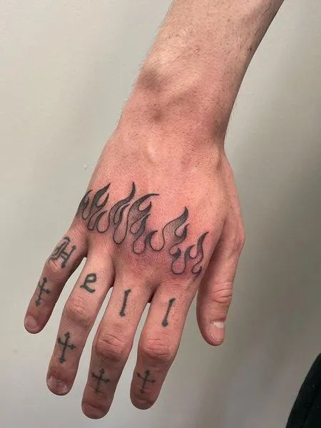 a hand with some tattoos on it and the word faith written in flames above it