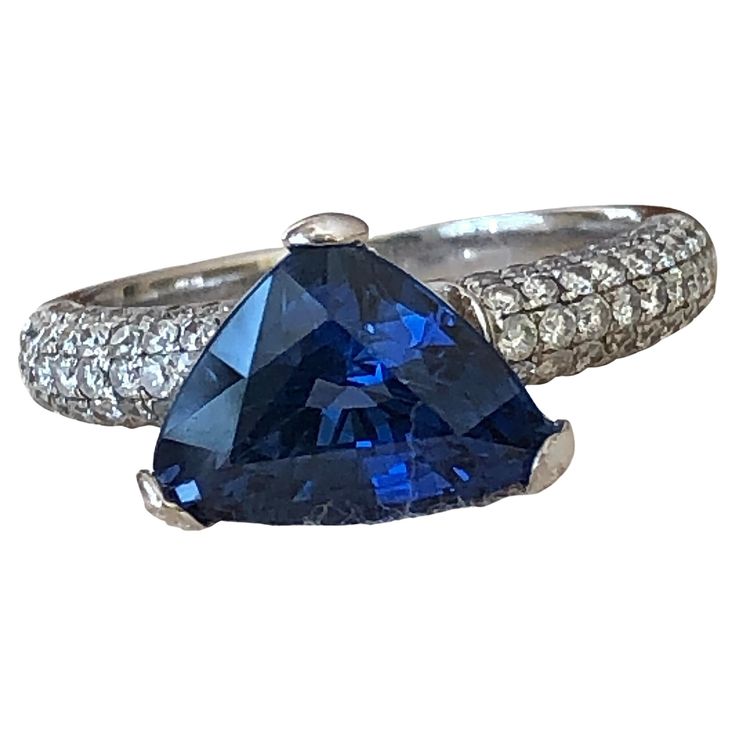 This Estate has an extraordinary cornflower Blue 3.76 Carat Sapphire set with Diamonds, this is a Wedding, Engagement Ring 18k White Gold Primary Stone: Natural Sapphire Sapphire Weight: 3.46 Carats Shape or Cut Sapphire: Trillion Color & Clarity Sapphire: Fine Vivid Cornflower Blue /VS Accent Stones: Round Brilliant Cut Diamonds Average Color & Clarity Diamonds: G-H/SI Total Diamond Weight: Approx. 0.30 Carats Total Gemstone Weight: Approx. 3.76 carats Composition: Solid White Gold 18K Total Ri Sapphire Diamond Engagement Ring, Diamond Sapphire Engagement Ring, Sapphire Diamond Engagement, Wedding Engagement Ring, Cornflower Blue, Natural Sapphire, Sapphire Diamond, Round Brilliant Cut Diamond, Diamond Wedding