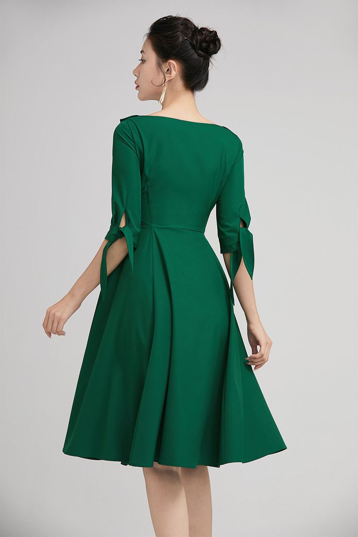 "The green swing dress with lapel collar is made of high quality polyester. The full cut romantic knee-length skirt with pleating details sways gently with every step. The tailored fitted bodice with a hidden side zip, defines the bust and waist. The elbow length sleeves are finished off with tie belt cuff. A row of buttons in the front and the Lapel Collar gives our classic dress timeless vintage charm, striking just the right balance between elegance and comfort. DETAILS * Satiny fabric, conta Solid A-line Dress With Pleated Waist, Solid A-line Pleated Dress, Green Solid Color Evening Dress, Green Solid Color Midi Dress For Party, Chic Fit And Flare Solid Color Midi Dress, Solid Color Knee-length Dresses With Pleated Waist, Solid Knee-length Dresses With Pleated Waist, Solid Color Midi Length Cocktail Dress, Semi-formal Knee-length Dress With Box Pleat