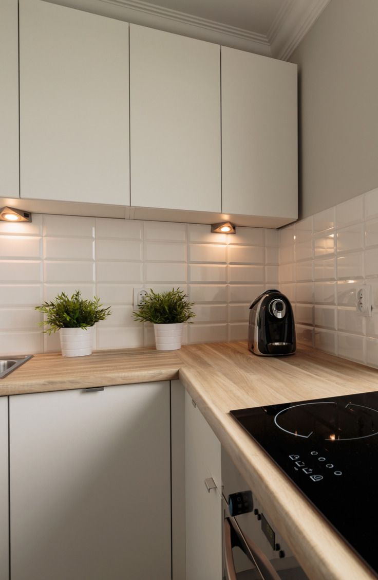 a kitchen with white cupboards and a black stove top oven