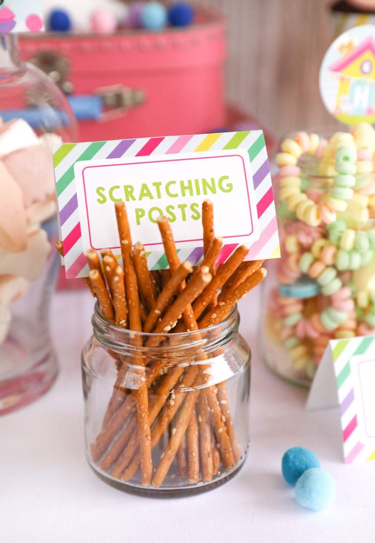 a jar filled with lots of candy sitting on top of a table next to other candies