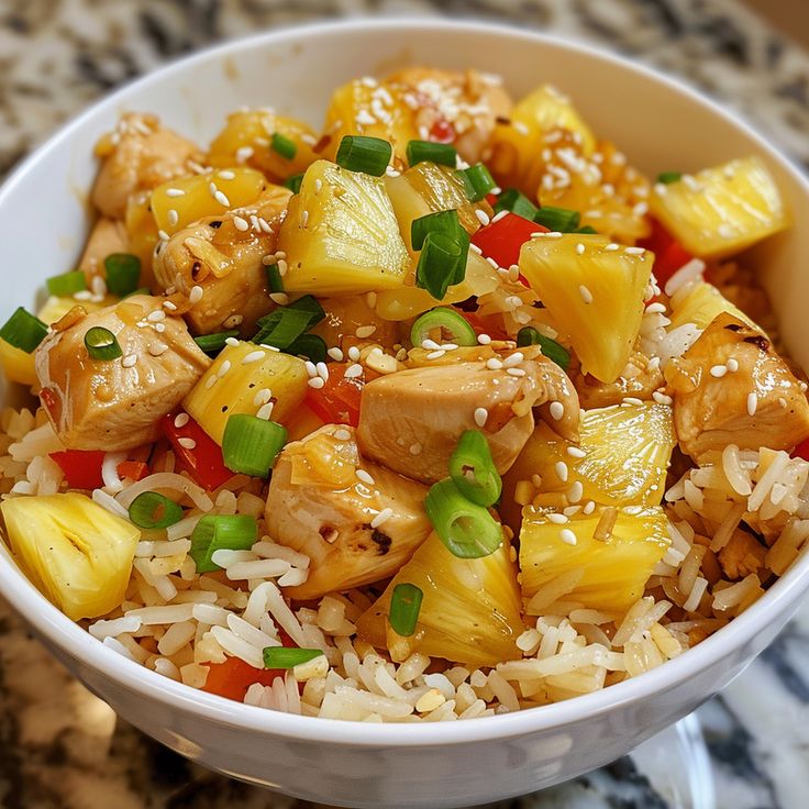 a white bowl filled with pineapple chicken and rice