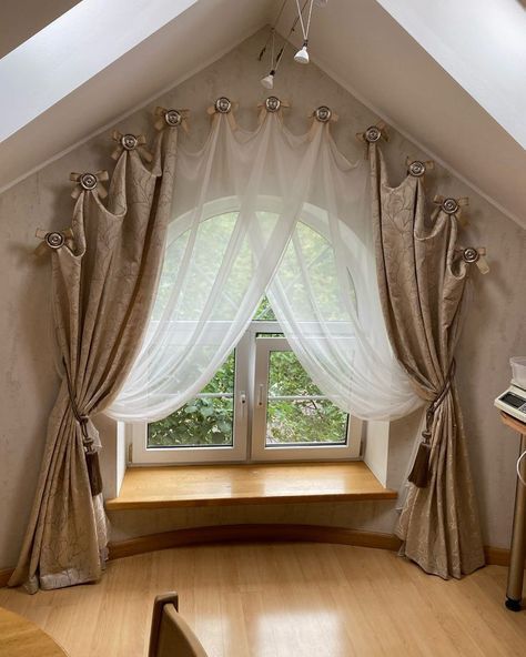 a room with a window and some curtains on the windowsill, in front of a wooden floor