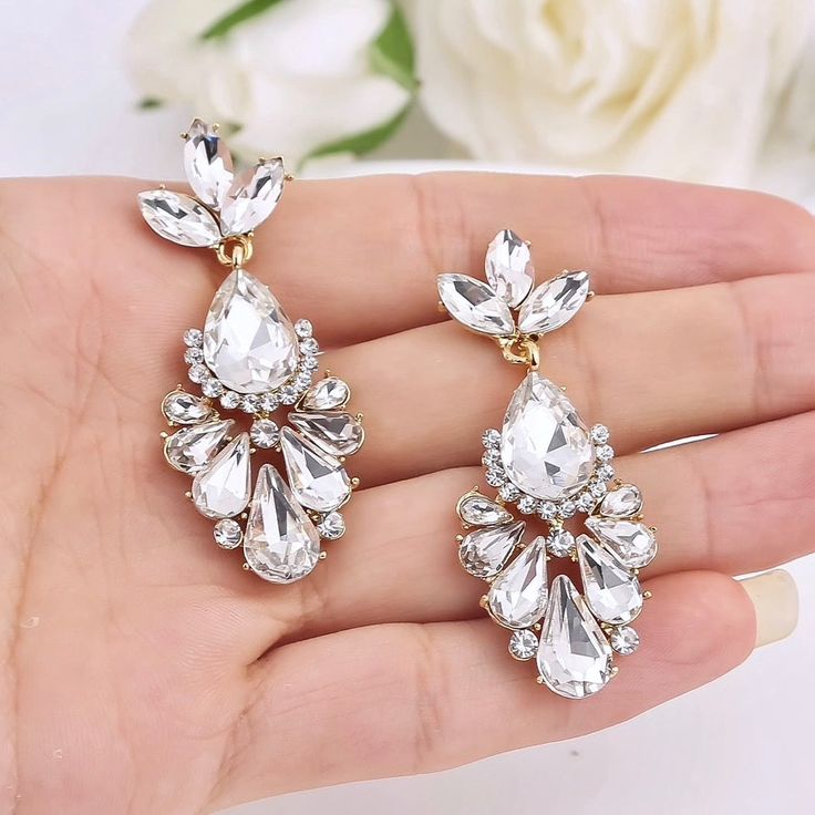 A delightfully unique pair of bridal earrings with an incredible sparkle! Lightweight, the earrings are adorned with flawlessly faceted rhinestone crystals that capture the light in a dazzling array of sparkles, and are rhodium/gold plated for a bright finish which enhances the intricate detailing and conveys a modern take on old elegance. Length: 2" (approx. 5cm). Available in Silver and Yellow Gold finishes. To make your choice select your preferred finish from the dropdown menu. Hypoallergeni Glamorous White Diamond Chandelier Earrings, Dazzling White Crystal Earrings, White Sparkling Crystal Bridal Earrings, Sparkling White Crystal Bridal Earrings, Glamorous White Chandelier Earrings With Sparkling Stones, Diamond White Sparkling Bridal Earrings For Wedding, Diamond White Sparkling Stones Bridal Earrings For Wedding, Diamond White Bridal Earrings With Sparkling Stones For Wedding, White Diamond Crystal Earrings For Wedding