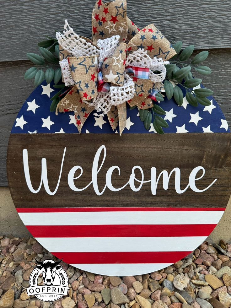 a wooden welcome sign with an american flag bow