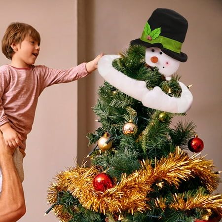 a man and boy standing next to a christmas tree with a snowman on it