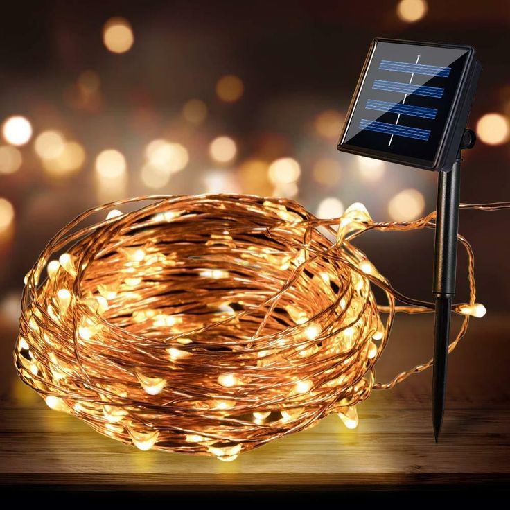 a solar powered string light on top of a wooden table