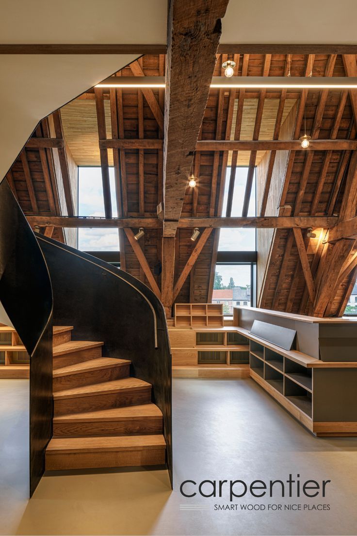 the inside of a building with wooden stairs and open space to another room that has large windows