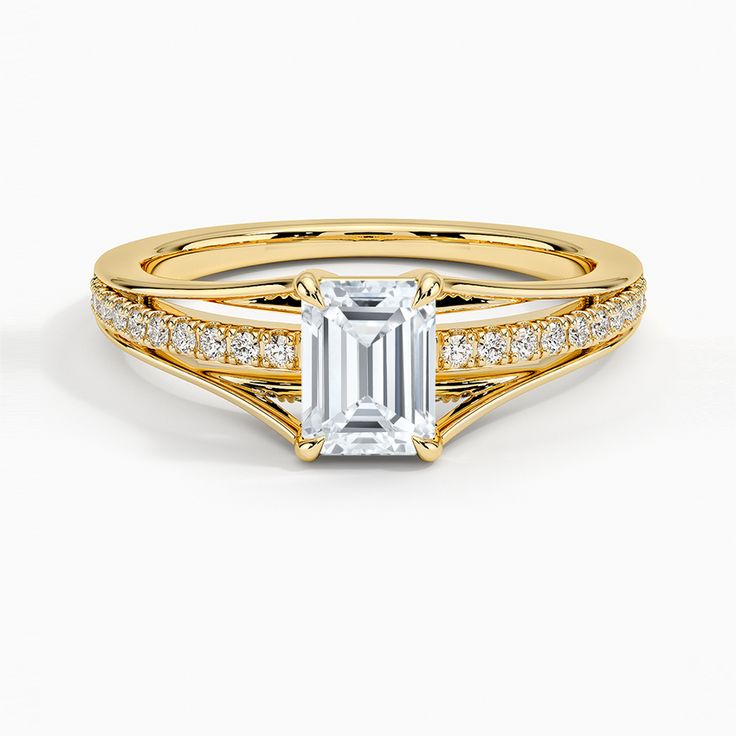 a yellow gold ring with an emerald stone and diamonds on the band, set in 18k