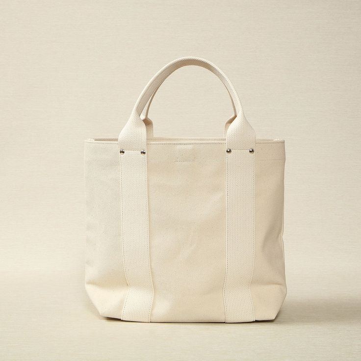 Unbleached Canvas Medium Tote 16.5" x 5.5" x 12.6" Made in Japan Threadline is a Japanese-manufactured line of heavy canvas bags designed for everyday use. Large White Canvas Bag For Everyday Use, Large Beige Canvas Shoulder Bag, Large Natural Canvas Bag For Daily Use, Large White Everyday Canvas Bag, White Canvas Shoulder Bag With Reinforced Handles, Classic Beige Cotton Canvas Bag, Large Beige Canvas Bag, Large Natural Canvas Bag For Everyday Use, Classic Rectangular Waxed Canvas Bag