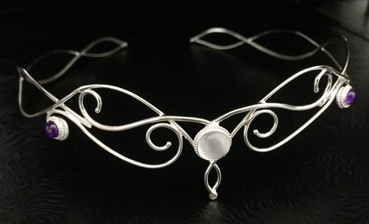 This magical, fairytale inspired wedding circlet is regal, elegant and bohemian wrapped into one fantastic package! I will fabricate this headpiece in sterling silver, featuring a glowing 10mm Moonstone with two side, 6mm Amethyst cabochons. This headpiece will fit behind threads for a comfortable fit. I use a jewelers stretch cord to tie off one end, and you tie the other end for a snug and secure fit to your head shape. You can gently manipulate to fit. Being Sterling silver, it will hold its Ethereal Adjustable Silver Jewelry, Ethereal Adjustable Jewelry For Festivals, Whimsical Adjustable Wedding Jewelry, Handmade Wedding Jewelry Headband, Elegant Moonstone Jewelry For Festivals, Mystical Crown Headpiece For Wedding, Mystical Moonstone Wedding Jewelry, Ethereal Silver Wedding Jewelry, Ethereal Silver Jewelry For Wedding