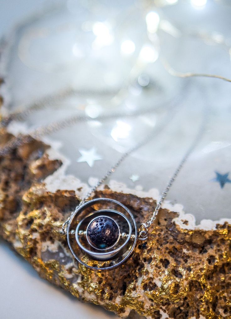 If you like astronomy, galaxies and outer space, this spinning necklace is the perfect accessory for you. This beautiful piece is made with 3 silver-plated brass rings, elegantly placed one inside the other to create a pendant inspired by the planetary galactic orbits. The inner piece is Natural Lava Stone Bead and imitates the texture and shape of an asteroid. ✦ You can spin the necklace! It's truly satisfying and entertaining to spin while you're wearing it! It's almost anti-stress! Such a del Cosmic Style Handmade Jewelry As A Gift, Handmade Cosmic Jewelry For Gifts, Handmade Cosmic Style Jewelry For Gifts, Space-themed Pendant Jewelry For Gift, Space-themed Pendant Jewelry Gift, Silver Space-themed Jewelry Gift, Space-themed Sterling Silver Jewelry Gift, Handmade Silver Cosmic Jewelry, Sterling Silver Space-themed Jewelry