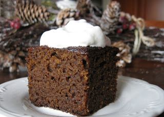 a piece of cake sitting on top of a white plate next to a pine cone