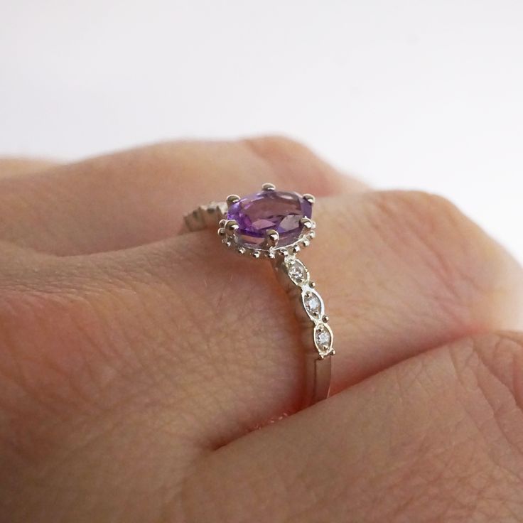 Introducing the exquisite "Juliet" Amethyst and White Topaz Ring – a timeless symbol of love and elegance. Crafted with passion and precision, this enchanting piece will captivate hearts and turn heads wherever it graces your hand. At the center of this ring lies a resplendent amethyst gemstone, deeply alluring with its regal purple hue. The amethyst, known for its association with tranquility and balance, embodies the spirit of royalty, making you feel like a true queen. Its mesmerizing violet Timeless Symbol, Symbol Of Love, White Topaz Rings, Purple Hues, Moon Child, Love Symbols, Topaz Ring, Amethyst Gemstone, White Topaz