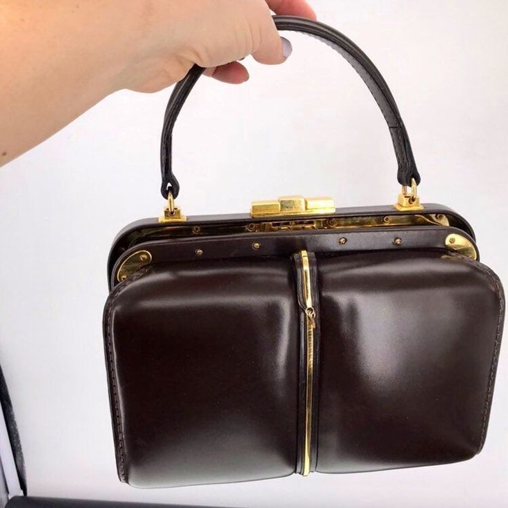 "Vintage circa 1950's Fernande Desgranges Cadillac Handbag in a Rich Chocolate Brown Leather accented in a great abundance of Brass Hardware. In fantastic condition with very light wear. As found at DC estate, from travelers of whom often visited Paris. I have not detailed,cleaned or polished, but it looks very good as you can see. Works perfectly Clean interior Signed \"Genève Paris Nice - Fernande Desgranges - Made in France - Déposé\"in gold letters. Has dangle in front, looks to have had a p Luxury Elegant Vintage Fashion Bags, Luxury Vintage Pre-owned Shoulder Bag, Luxury Vintage Flap Bag For Business, Classic Luxury Pre-owned Bags, Vintage Luxury Bags With Logo, Luxury Vintage Shoulder Bag With Luggage Sleeve, Luxury Vintage Box Bag With Detachable Handle, Luxury Vintage Shoulder Bag With Hasp Closure, Luxury Vintage Bags With Pockets