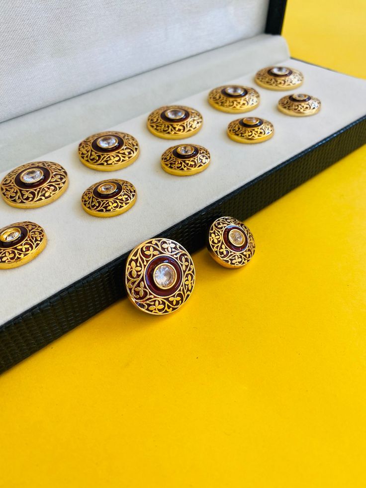 Each button is handcrafted and enamelled by the finest craftsmen in Jaipur. Handcrafted Indian Sherwani Button,Jodhpuri Maharaja Look Kundan Meena Jewellery,Gold plated Button Size:  Big : 22mm Diameter            Small : 18mm Material : Brass With !4k Gold plating                   Silver 925 With Certification The price reflected is for 7 big and 6 small buttons. All our pieces are plated with gold and secured with a high quality coating to increase the life of the plating we provide a proper Designer Gold Sets With Motifs, Bollywood Style Formal Meenakari Sets, Traditional Kundan Formal Sets, Traditional Kundan Sets For Formal Occasions, Designer Sherwani With Motifs For Eid, Designer Eid Sherwani With Motifs, Elegant Meenakari Traditional Wear As A Gift, Traditional Gold Sherwani With Cutdana, Designer Bandhgala With Motifs For Festive Season