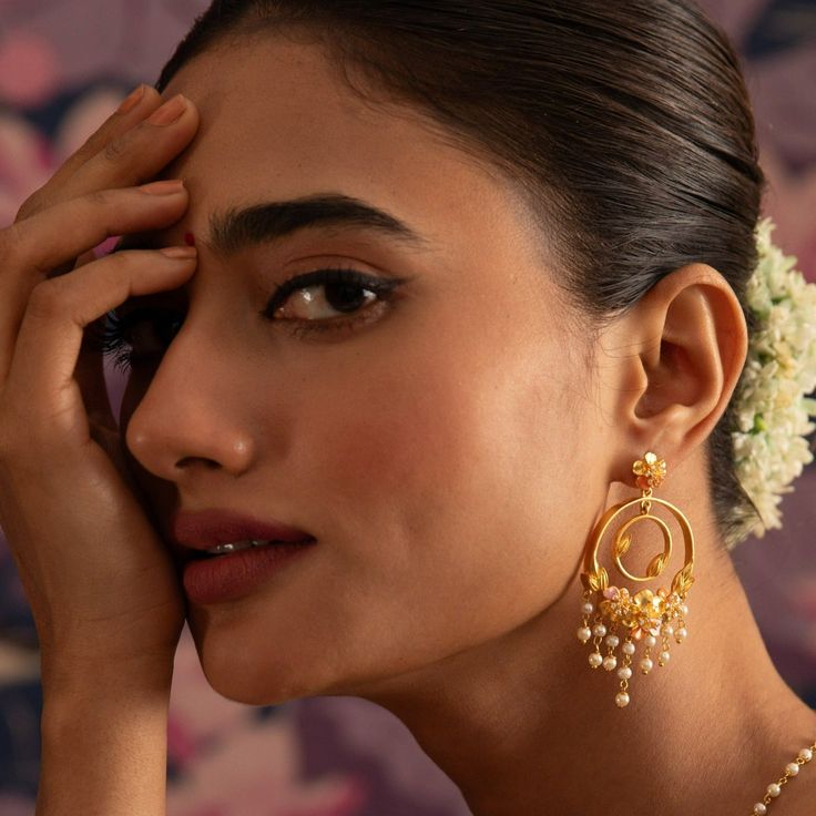 Description Tarinika’s Jalaja Collection celebrates the beauty and grace of flowers and pearls. The collection features exquisite gold-plated jewelry with floral designs, with soft enamel paint, and hand-woven pearl chains. This statement chandbali earring features two hoops. It adds a touch of glamour to any festive or wedding occasion. Details & Specifications: Materials used: Brass Alloy with Matte Gold & Enamel plating Weight – Earring-21.40 gm Length – Earring-7 cm Make it custom Want to m Elegant Chandbalis With Cutdana For Navratri, Elegant Cutdana Chandbalis For Navratri, Elegant Chandbalis For Navratri Festive, Elegant Navratri Festive Chandbalis, Elegant Festive Chandbalis For Navratri, Festive Bridal Earrings With Meenakari, Elegant Meenakari Chandbalis For Navratri, Elegant Meenakari Chandbalis For Diwali, Elegant Danglers For Navratri