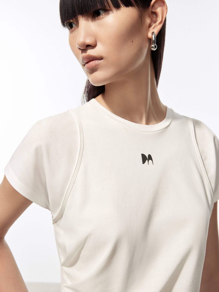 MO&Co. Women's Layered Detail Cotton T-shirt Made from soft, breathable cotton, this tee is designed for ultimate comfort and durability. It features a bold "M" graphic across the chest and a layered effect for a unique texture and visual interest. The simple, basic style pairs easily with your favorite jeans or skirts. Features : - Slim fit- Crewneck and short sleeves- M graphic print on chest- Layered effect, comfy cotton Code: MBD2TEET54The back length of size S is 50.5cmMATERIALS & CARE Mate White Stretch Muscle Tee With Crew Neck, Modern Short Sleeve Top With Logo Print, Athleisure Fitted Crew Neck T-shirt, Sporty Crew Neck T-shirt For Layering, Fitted Short Sleeve Sporty Muscle Tee, Sporty Fitted Everyday T-shirt, Sporty Fitted Short Sleeve Muscle Tee, Modern Cotton Sports Tops, Spring Athleisure Short Sleeve Muscle Tee