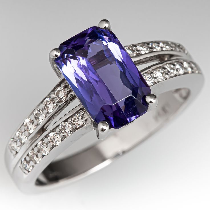 This wonderful ring is centered with one (1) cut-cornered rectangular mixed cut natural tanzanite set into a four-prong setting. The ring has a split shank design and is accented with two-rows of six (6), bead set, round brilliant cut diamonds on each side. The ring measures 10.0mm at the top, rises 6.5mm above the finger, tapering to 2.7mm wide and 1.3mm thick at the base of the shank. This ring is currently a size 7. Rectangular Sapphire Ring With Accent Stones For Formal Occasions, Formal Rectangular Sapphire Ring With Accent Stones, Rectangular Brilliant Cut Sapphire Ring For Formal Occasions, Formal Tanzanite Emerald Cut Rings, Formal Emerald-cut Tanzanite Rings, Fine Jewelry Tanzanite Rings In Radiant Cut, Radiant Cut Tanzanite Ring For Formal Occasions, Elegant Tanzanite Ring In Radiant Cut, Elegant Tanzanite Ring With Radiant Cut