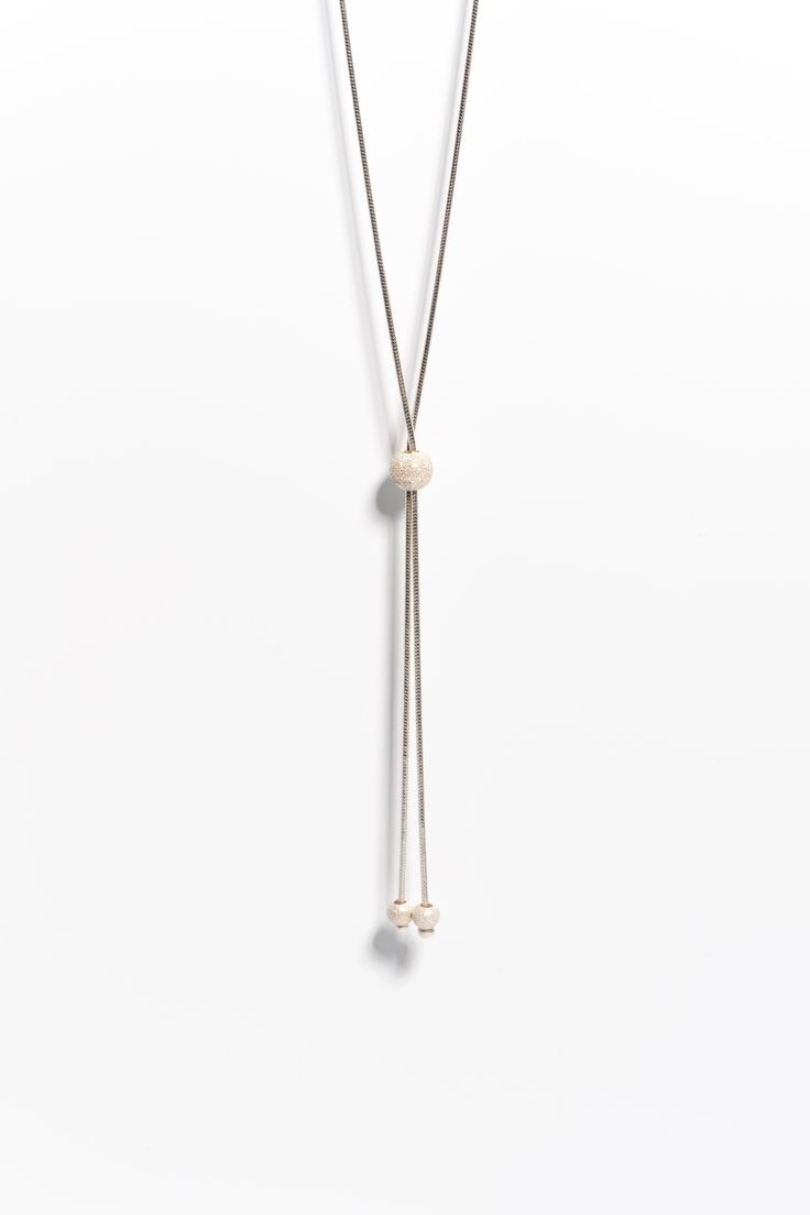 Add a touch of elegance and versatility to your jewelry collection with our Sterling Silver Lariat Layering Necklace. This stunning and unique necklace is expertly handcrafted from high-quality sterling silver, and features glistening silver beads that add a touch of shimmer and sparkle to any outfit. The lariat design of this necklace makes it perfect for layering with other necklaces, or for wearing alone as a statement piece, making it a versatile addition to your jewelry collection. Each nec Adjustable White Lariat Drop Necklace, White Adjustable Lariat Drop Necklace, Elegant Lariat Beaded Necklaces With Adjustable Chain, Adjustable Single Strand Lariat Necklace With Round Beads, Elegant Lariat Beaded Necklace With Adjustable Chain, Minimalist Silver Jewelry With Dangling Beads, Adjustable Lariat Necklace With Dangling Round Beads, Elegant Adjustable Lariat Necklace With Round Beads, Adjustable White Gold Lariat Necklace