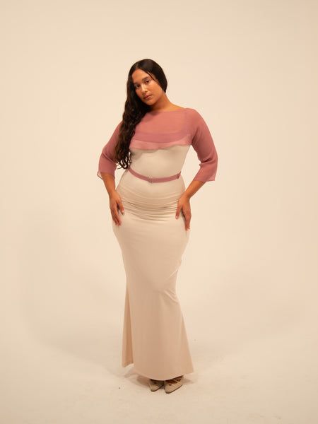 a woman in a white and pink dress posing for the camera with her hands on her hips