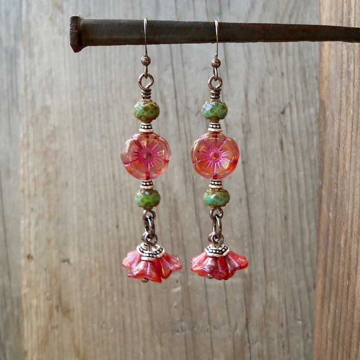 So excited to show off these new beads. I happen to see these sitting together and knew they needed to stay together! The beautiful little bell flower beads are 5x8mm, translucent red orange pink base, coated in light golden Picasso and pink metallic wash. So beautiful! They are complimented by another new bead. It is a 12mm, hibiscus flower bead in a mix of pink glass, with deep orange striations. They are finished with golden metallic luster and pink wash remaining in the recessed grooves. The Bohemian Jewelry With Dangling Beads For Spring, Whimsical Nickel Free Dangle Flower Earrings, Whimsical Adjustable Drop Earrings, Bohemian Spring Jewelry With Dangling Beads, Spring Dangle Jewelry With Dangling Beads, Bohemian Flower Earrings Nickel Free, Flower Drop Earrings With Dangling Beads For Gifts, Vintage Dangle Earrings For Spring, Bohemian Jewelry With Ear Wire For Spring