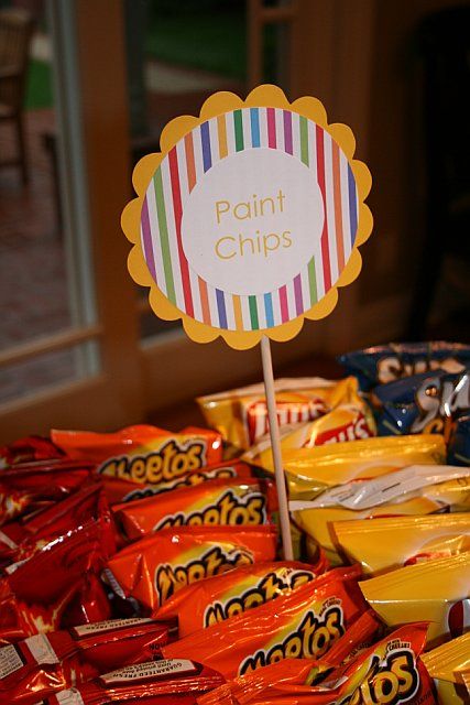 a table topped with lots of candy bags and a sign that says paint chips on it