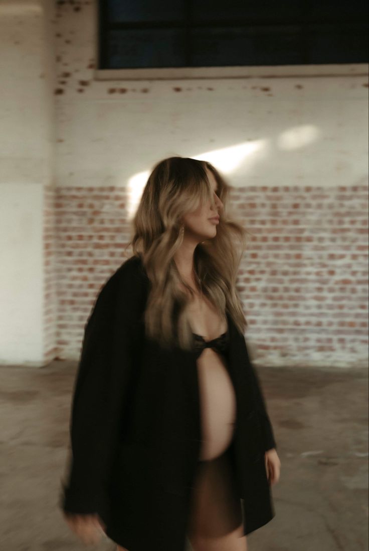 a woman in a black jacket is walking down the street with her legs spread out