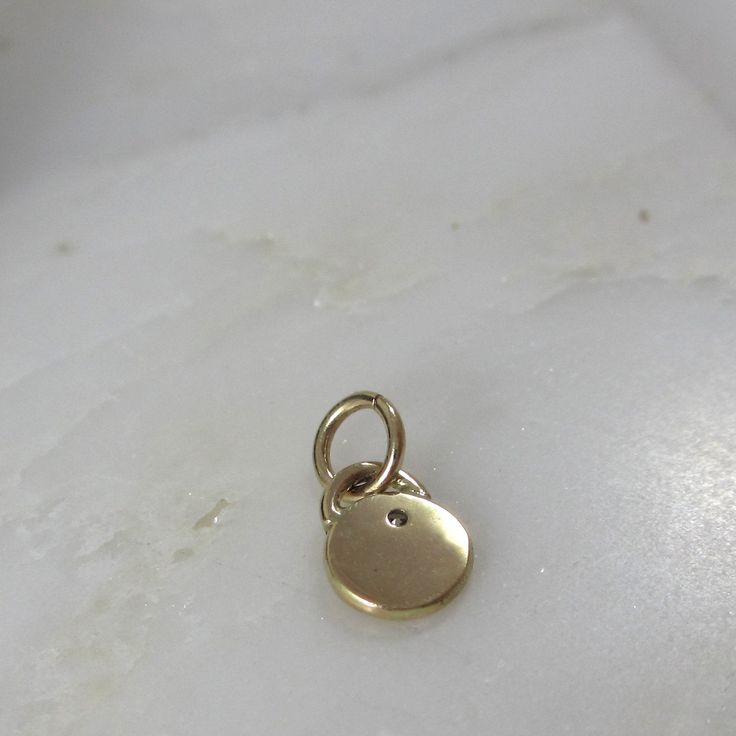 This adorable charm is entirely hand-crafted from recycled 14k gold, which I melt down and form into this petite, organic little pendant. It is then hand-stamped with two sweet leaves and is finished with a genuine flush set diamond. Available with either a shiny gold or satin finish. Includes an open jumpring for hanging. It will be your favorite new spring necklace! *This listing is for one Diamond Petal Charm only. Chain not included and shown with other charms for layering options. :: Solid Dainty Yellow Gold Brass Charm Necklace, Everyday Round Minimalist Charms, Minimalist Everyday Round Charms, 14k Gold Pendant Charm Necklace With Vintage Charm, 14k Gold Vintage Charm Pendant Necklace, Everyday Vintage Charm Round Pendant Jewelry, Everyday Yellow Gold Pendant Charms, Minimalist Everyday Pendant Charms, Recycled Gold Charm Necklace With Round Pendant