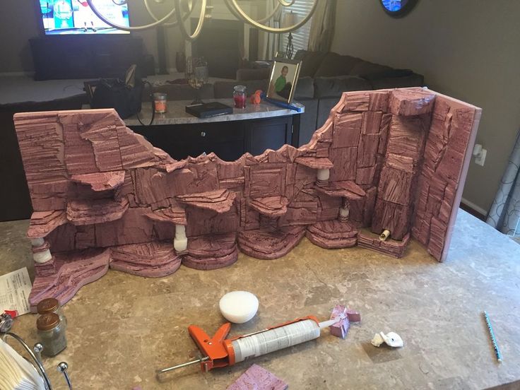 some construction tools are laying on the counter in front of a large rock formation that looks like it has been cut into pieces