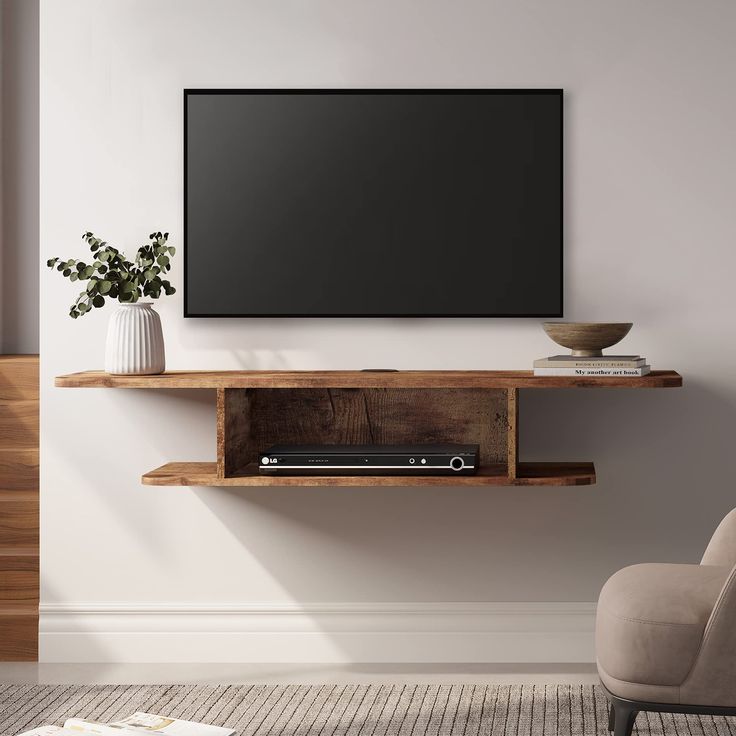 a flat screen tv mounted to the side of a wooden shelf next to a plant