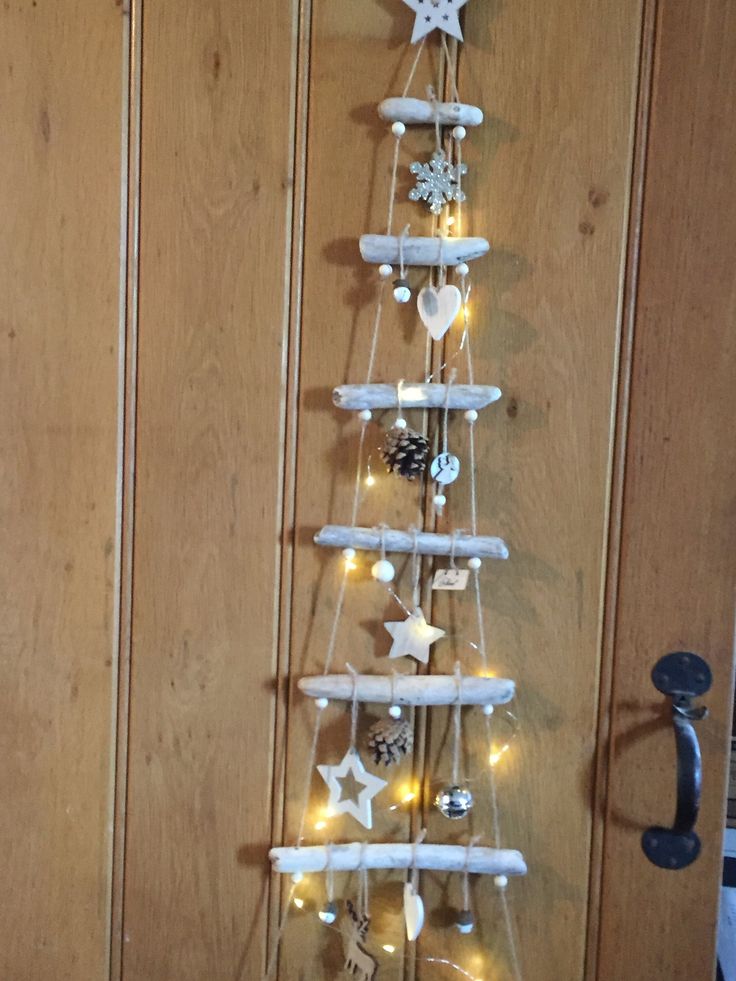 a white christmas tree made out of wooden planks with lights on the top and bottom