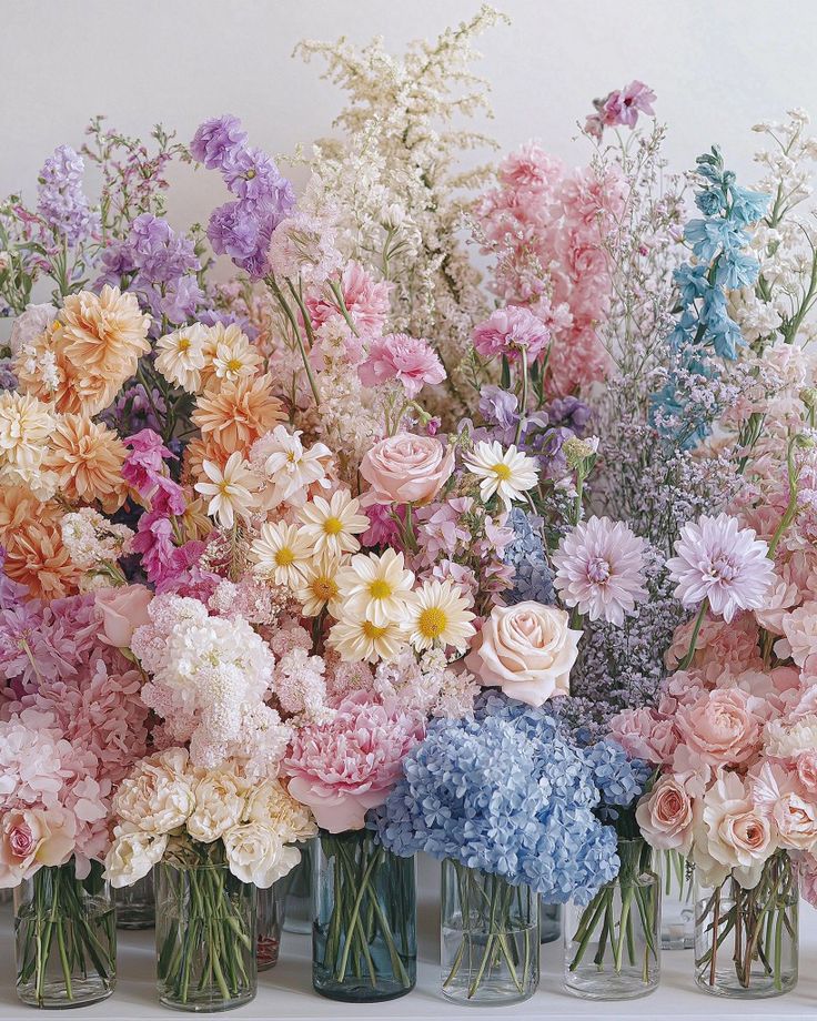 several vases filled with different colored flowers