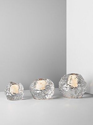 three glass bowls sitting next to each other on a white counter top in front of a gray wall