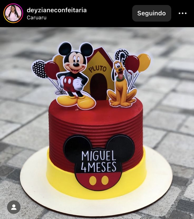 a red and yellow cake with mickey mouse on top