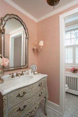 a bathroom with pink walls and an antique style vanity in the corner, along with a white radiator