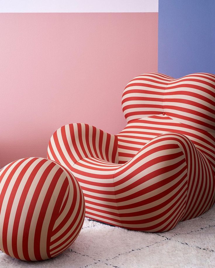 two red and white striped chairs sitting next to each other on top of a floor