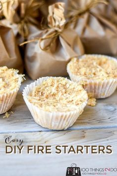 three cupcakes sitting on top of a wooden table next to brown paper bags