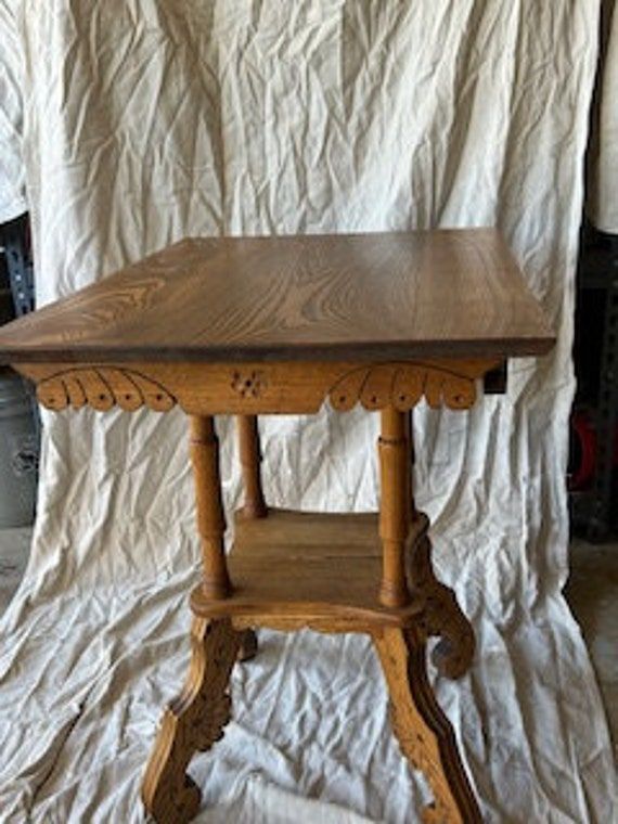 a wooden table sitting on top of a white sheet