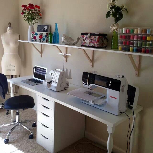 a sewing machine sitting on top of a table next to a desk with two chairs