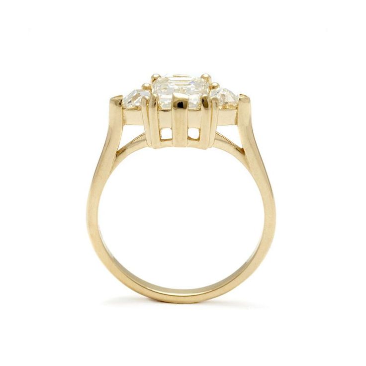 a yellow gold ring with three stones in the center and two diamonds on each side