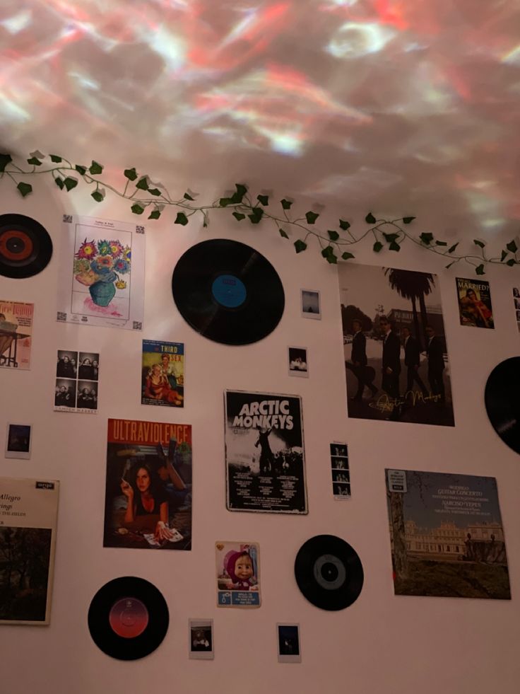 there are many records on the wall with plants growing out of them and hanging from the ceiling